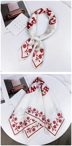 Detail of silk satin scarf with red rose pattern and elegant artistic typography
