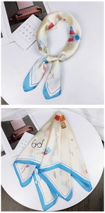 Detail of hand-painted cream silk scarf with blue borders and lifestyle prints