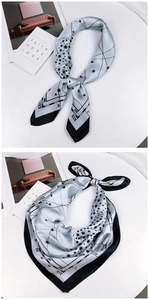 Detailed macro view of silver-grey silk scarf with black starry sky and Roman numeral print