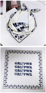 Detailed view of cream silk scarf with navy rose print and GRL PWR text pattern
