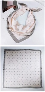 Flat lay of a pink square silk scarf with camellia print and elegant grey borders