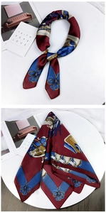 Detail of vintage square silk scarf with bow patterns and elegant dark blue and burgundy contrast