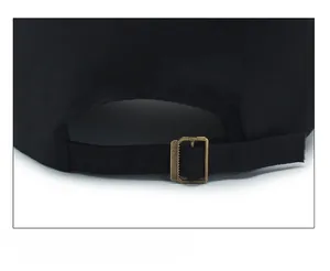 Détail de la boucle métallique réglable et de la sangle en coton noir de la casquette