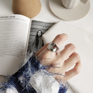 Close-up of wide 925 silver ring with irregular organic texture and high mirror polish