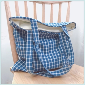 Détail du sac cabas en toile vichy bleu et blanc montrant la fermeture et la texture