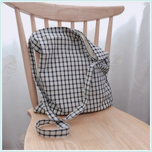 Sac fourre-tout en toile à carreaux noir et blanc de style japonais sur chaise en bois