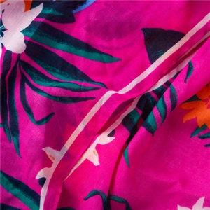 Macro shot of tropical leaf print on cotton linen fuchsia scarf with vibrant floral details