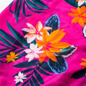 Close-up of tropical floral pattern on cotton linen scarf with vibrant rose red texture