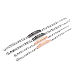 Detail of his and hers stainless steel bracelets with engraved king and queen charms