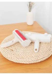 Détail d'une brosse anti-poils pour animaux avec tissu rouge sur table en bois