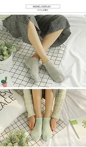 Close-up of low-cut cotton invisible socks in light gray and green colors on a model