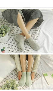 Close-up of low-cut cotton invisible socks in light gray and green colors on a model