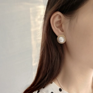 Detailed close-up of 925 sterling silver gold-plated stud earring with white pearl inlay