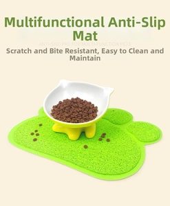 Detail of green paw-shaped waterproof PVC pet litter mat with a cat food bowl