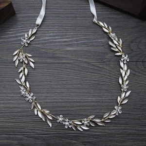 Serre-tête de mariée fait main avec feuilles argentées et perles sur fond de bois
