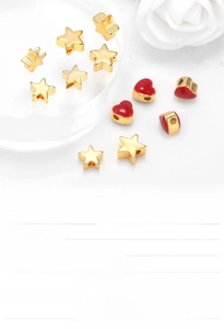 Detailed view of gold plated heart and star spacer beads for DIY jewelry making