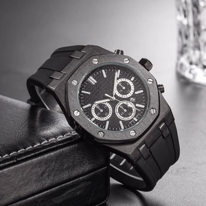 Men's black chronograph watch with octagonal bezel and rubber strap on premium display box