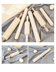 Macro detail of polished beechwood rolling pins with flour and eggs on grey linen texture