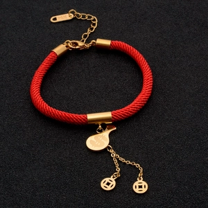 Close-up of red braided rope bracelet with gold money bag charm and K14 lobster clasp