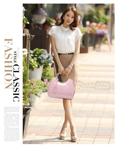 Detail of pink patent leather shoulder bag with a gold metal ring handle and decorative tag