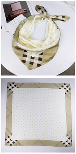Detail of square silk scarf with yellow polka dots and brown plaid border patterns