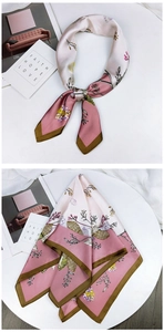 Detail of pink floral silk scarf with butterflies and dark olive border on white stand