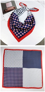 Detailed view of square silk scarf with red, white, and navy blue floral patterns
