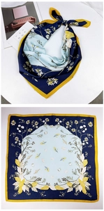 Detailed pattern of small square silk scarf with floral and seashell motifs in navy and yellow