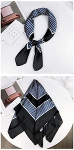 Detail of navy blue polka dot silk scarf with striped patterns and smooth glossy texture