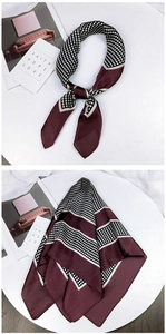 Close-up of wine red silk scarf featuring classic polka dots and smooth satin texture