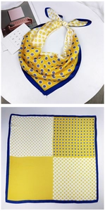 Detail of yellow and white printed silk scarf with floral patterns and a navy border