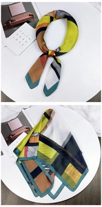 Detail of a square silk scarf with geometric patterns in mustard yellow and navy blue