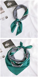 Detail of silk-like scarf featuring dark green polka dots and striped color-block design