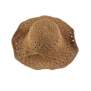 Brown crochet straw sun hat with wide wavy brim and delicate bow accent for beach travel
