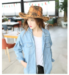 Detail of western cowboy hat with tassels and denim jacket on a female model