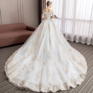 Exquisite white off-shoulder bridal gown with gold lace embroidery and long train