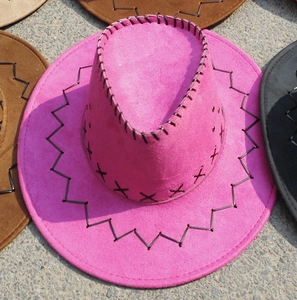 Close-up of pink suede cowboy hat with black cross-stitch seam detailing on the brim