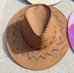 Top view of a brown suede cowboy hat with stitched brim and side ventilation holes