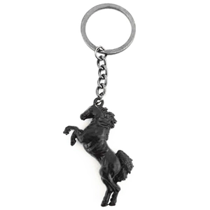 Close-up of a creative black metal horse-shaped keychain with intricate carving details