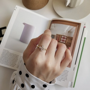 Close-up of minimalist gold cross ring with white zircon stones on a model hand