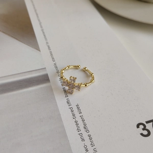 Macro shot of gold adjustable 925 silver ring with clear cubic zirconia flower detail