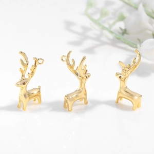 Detailed view of three gold reindeer charms for jewelry making on white background