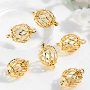 Detailed view of six gold hollow cage charms for handmade jewelry making on white background