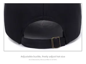 Detail of adjustable bronze metal buckle on a black cotton baseball cap for custom fit