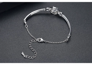 Detailed view of silver zircon bracelet with adjustable lobster clasp on textured surface