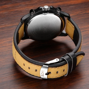 SOKI sport quartz watch with black case and brown leather strap on dark wood desk