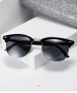 Close-up of semi-rimless Clubmaster sunglasses with silver rivet and grey lenses