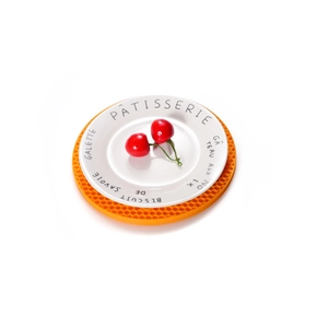 White ceramic plate with French text on an orange honeycomb silicone placemat