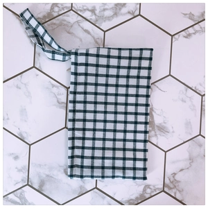 Detail of a minimalist black and white checkered fabric pouch with wrist strap