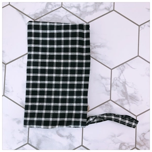 Close-up of black and white checkered fabric phone pouch with matching wrist strap